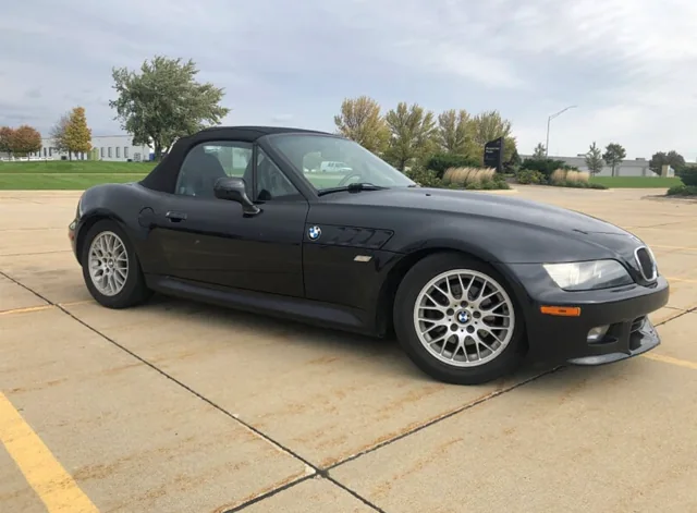 Black BMW Z3 with a fabric soft top and silver multi-spoke wheels.