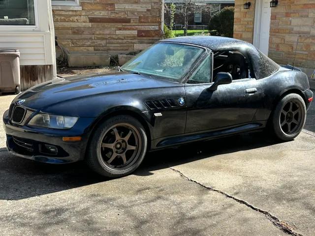 The black BMW Z3 with bronze wheels and its custom carbon hardtop.