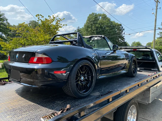Rear three-quarter view of the open-top Z3 secured on a flatbed.